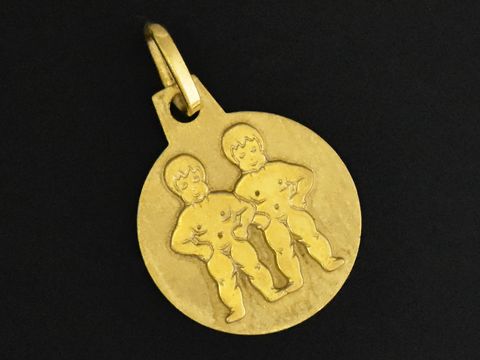 Gold Anhänger mit dem Sternzeichen Zwillinge, Durchmesser 12 mm, zeigt zwei stilisierte Figuren in kindlicher Darstellung, Hersteller Juwelier Harnisch.