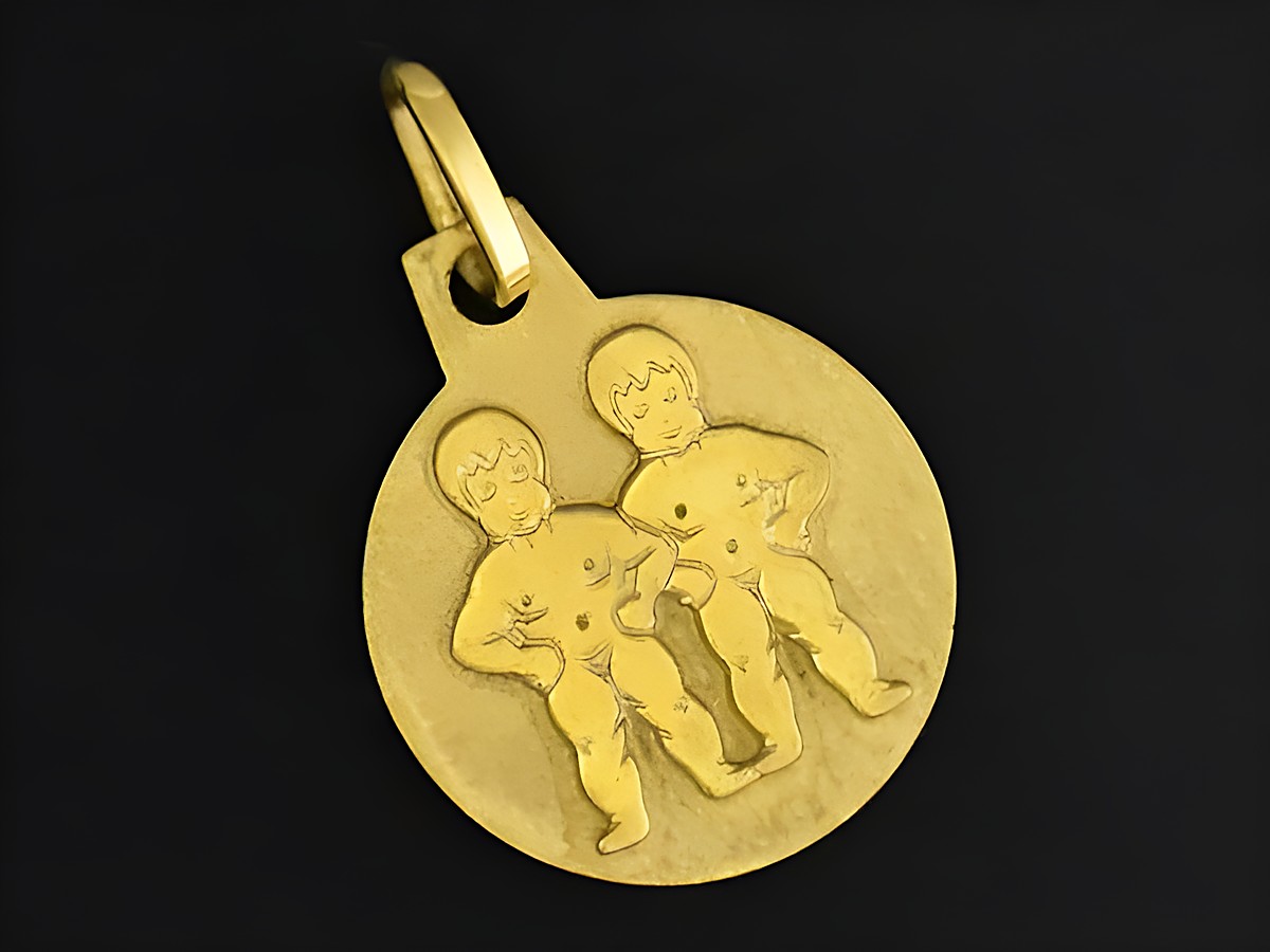 Gold Anhänger mit dem Sternzeichen Zwillinge, Durchmesser 12 mm, zeigt zwei stilisierte Figuren in kindlicher Darstellung, Hersteller Juwelier Harnisch.