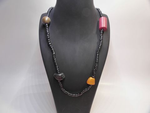 Holzkette Multiform 23 mm bunt 90 cm Holz Schmuck von Juwelier Harnisch, präsentiert auf einem schwarzen Hals display, zeigt farbige Holzperlen und unterschiedliche Formen.