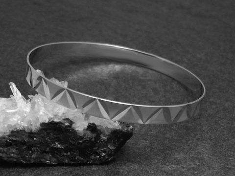 Silber Armreifen filigran 6,4 mm rhodiniert 20,5 cm Hersteller Juwelier Harnisch auf schwarzem Untergrund mit glitzernden Kristallen. Elegant und modern im Design.