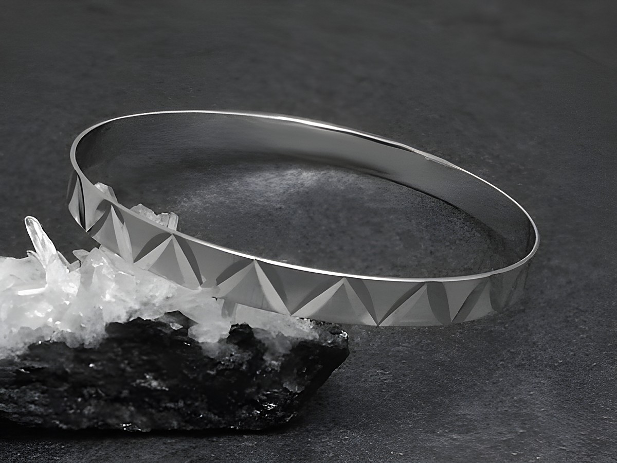 Silber Armreifen filigran 6,4 mm rhodiniert 20,5 cm Hersteller Juwelier Harnisch auf schwarzem Untergrund mit glitzernden Kristallen. Elegant und modern im Design.