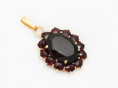 Ovaler Granat Schmuck Anhänger in Gold mit einer Größe von 25,2 mm, umgeben von mehreren facettierten Granaten, hergestellt von Juwelier Harnisch.