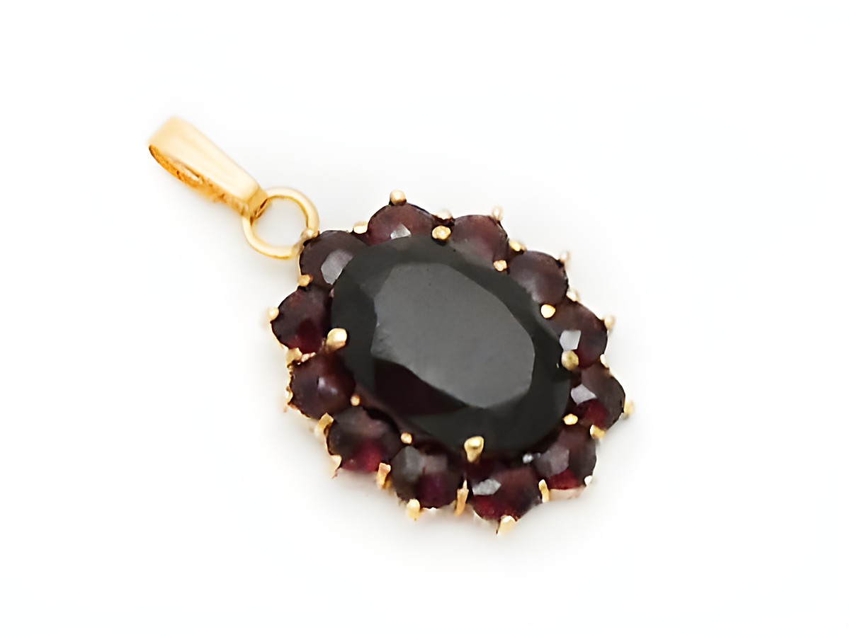 Ovaler Granat Schmuck Anhänger in Gold mit einer Größe von 25,2 mm, umgeben von mehreren facettierten Granaten, hergestellt von Juwelier Harnisch.