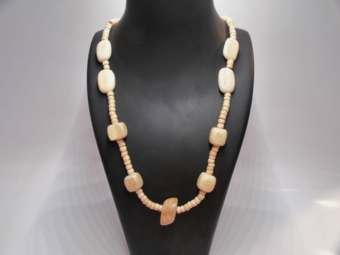 Holzkette aus naturbraunen Holzperlen, Multiform, 24 mm, 60 cm lang, von Juwelier Harnisch, idealer Schmuck für einen natürlichen Look, elegantes Design auf schwarzem Hintergrund präsentiert.