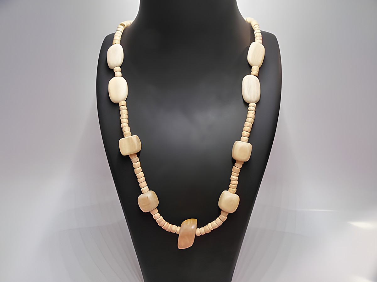 Holzkette aus naturbraunen Holzperlen, Multiform, 24 mm, 60 cm lang, von Juwelier Harnisch, idealer Schmuck für einen natürlichen Look, elegantes Design auf schwarzem Hintergrund präsentiert.