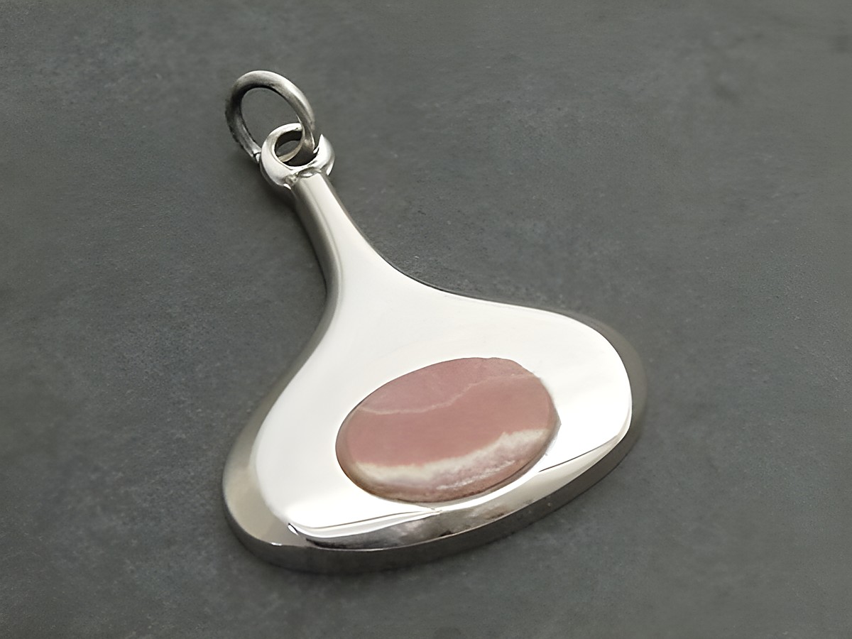 Retro Silber Anhänger mit rhodiniertem Finish und einem ovalen Rhodochrosit-Einsatz, in modernen und eleganten Linien, hergestellt von Juwelier Harnisch.