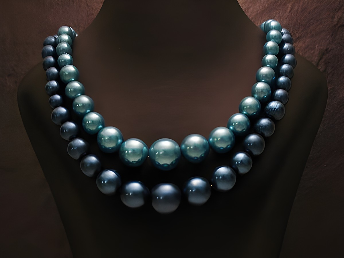 Zweireihige Kette runde Perlen neu blau, hergestellt von Juwelier Harnisch, elegante Perlenkette mit verschiedenen Blautönen und glänzendem Finish, ideal für besondere Anlässe.