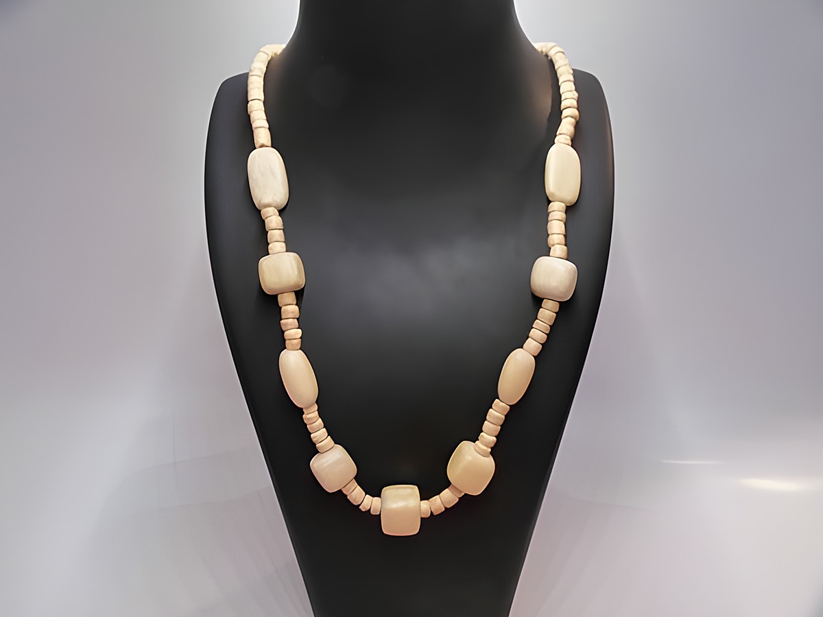 Holzkette Multiform 15 mm naturbraun 60 cm von Juwelier Harnisch, mit verschiedenen Holzperlen in naturbrauner Farbe, elegant präsentiert auf einer Schmuckpuppe.