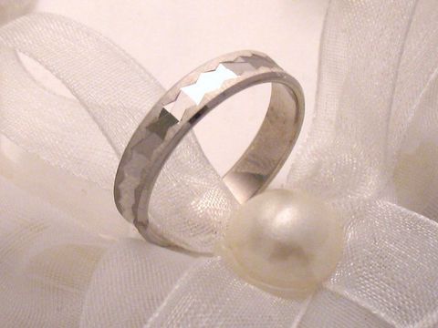 Trauring Ehering in Weißgold 333 mit feiner, facettierter Oberfläche, Größe 53/16,9, von Juwelier Harnisch, bis Größe 54/17,2, präsentiert vor zarter Schleifenverzierung.