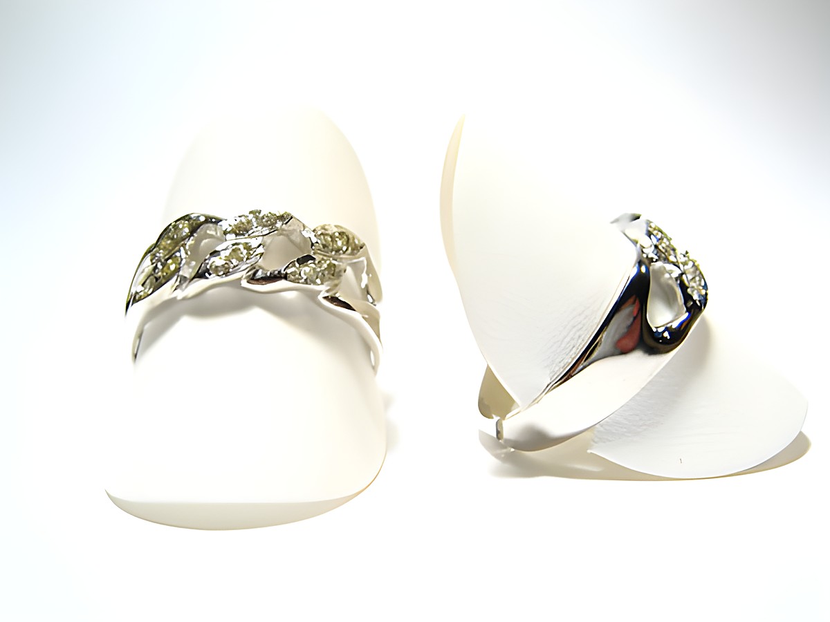 Designer Silber Ring rhodiniert mit weißen Steinen, Hersteller: Juwelier Harnisch, Ringe verstellbar, elegant präsentiert auf ringförmigen Halterungen, glänzende Oberfläche.