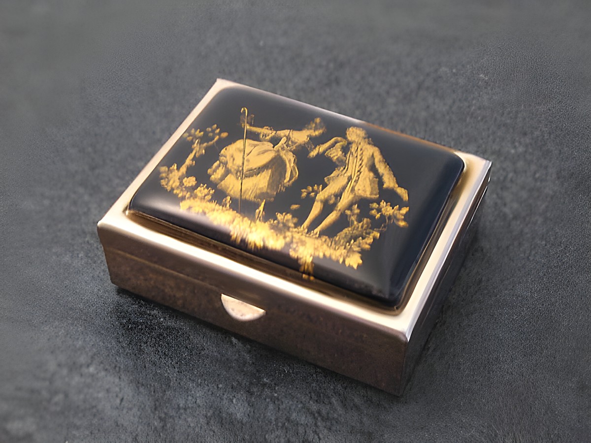 Multifunktionale Dose mit schwarzer Einlage und goldfarbenem Aufdruck, Hersteller Juwelier Harnisch, ohne Stein, zeigt eine dekorative Darstellung von Figuren in einer klassischen Szenerie.