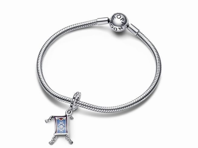 Das Bild zeigt ein Pandora Armband aus Sterling Silber mit einem charm in Form einer magischen Teppichrolle, verziert mit buntem Emaille.