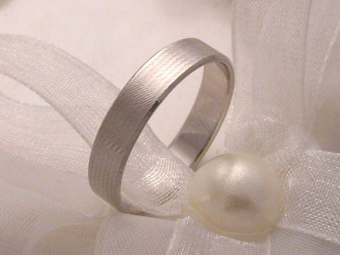 Trauring Ehering WHITE ELEGANCE aus weißgold 333 in Größe 64/20,4, elegant mit einer feinen Oberflächenstruktur, präsentiert auf einem hellen Satinband mit einer Perle.