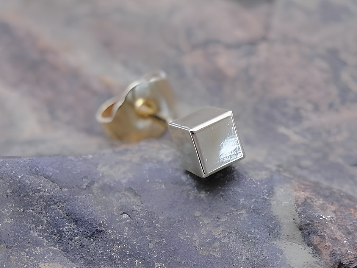 Filigraner unisex Ohrstecker in Gold mit würfelförmigem Design, hergestellt von Juwelier Harnisch, als Einzelohrring erhältlich.