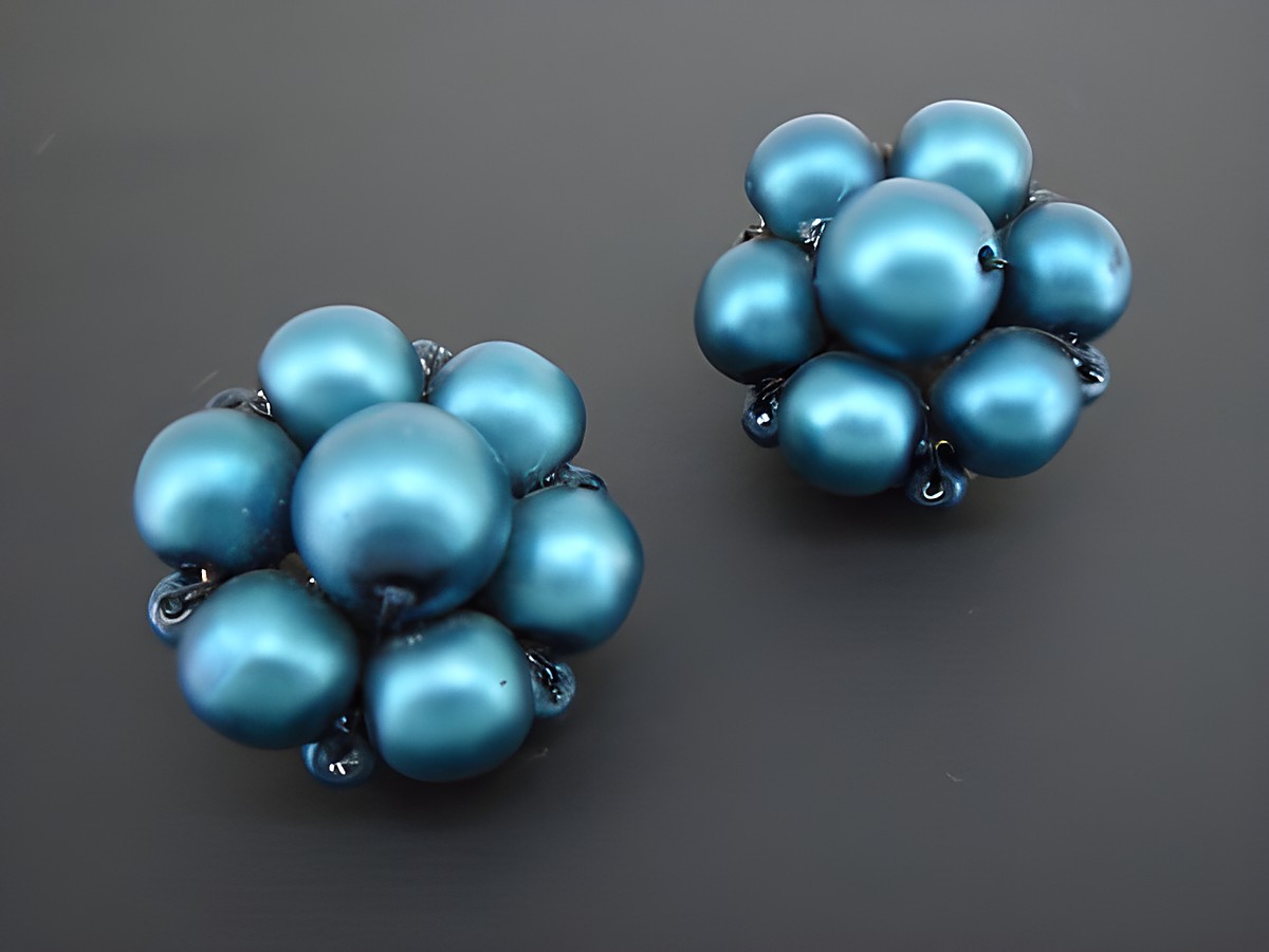 Ohrclip in blau mit blumigem Design aus goldfarbenem Material und seidenmatten synthetischen Zuchtperlen, Hersteller Juwelier Harnisch, klassisches und elegantes Schmuckstück.