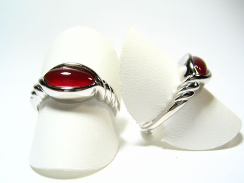Silber Ring rhodiniert mit Karneol in rot braun im 70er Look, Hersteller Juwelier Harnisch, Ringe verstellbar, stilvolle Präsentation auf weißen Aufstellern.