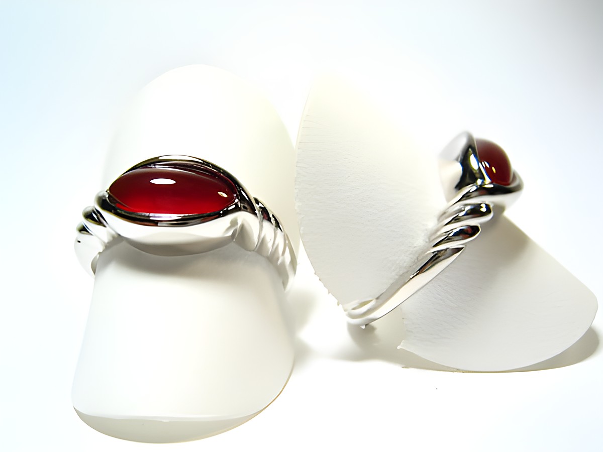 Silber Ring rhodiniert mit Karneol in rot braun im 70er Look, Hersteller Juwelier Harnisch, Ringe verstellbar, stilvolle Präsentation auf weißen Aufstellern.