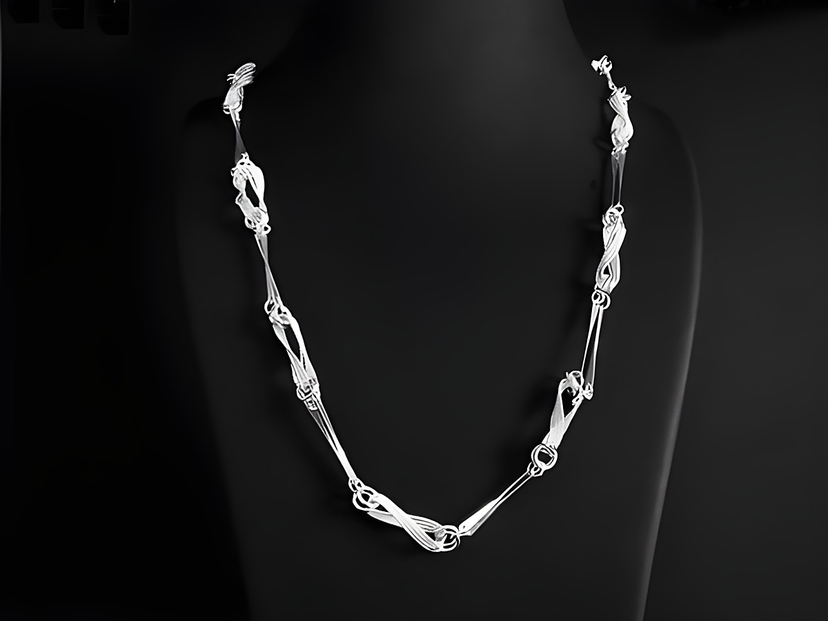 Lange Kette XXL versilbert im Design Collier mit einer Länge von 78 cm und einer Breite von 6,3 x 0,9 mm, elegant drapiert über einen schwarzen Hintergrund.