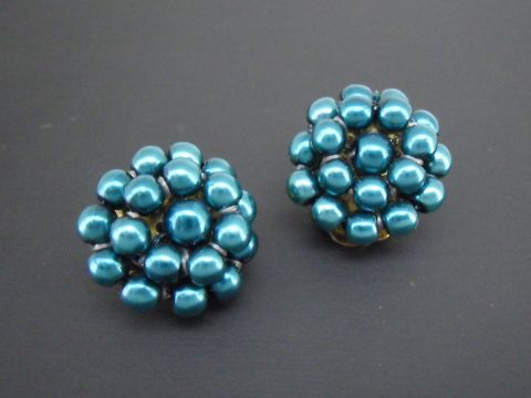 Dunkeltürkise Ohrclips aus synthetischen Zuchtperlen mit goldfarbener Fassung, designed vom Juwelier Harnisch, ideal für einen eleganten Look.