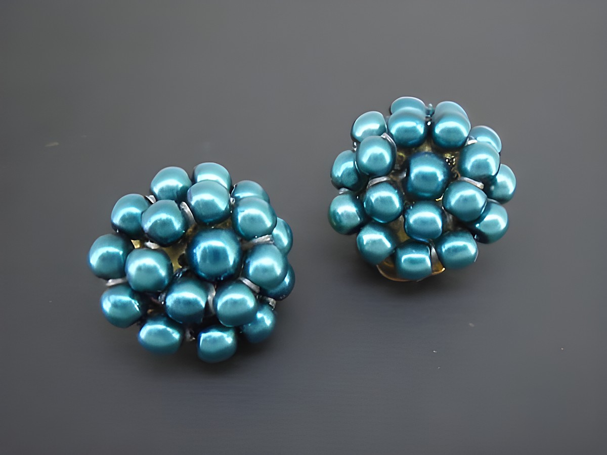 Dunkeltürkise Ohrclips aus synthetischen Zuchtperlen mit goldfarbener Fassung, designed vom Juwelier Harnisch, ideal für einen eleganten Look.