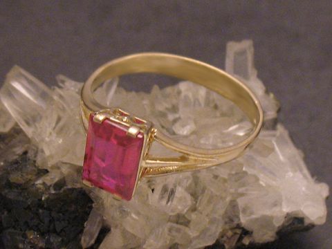Goldring aus Gold 333 mit einem roten unechten Stein in Größe 54. Hersteller ist Juwelier Harnisch, geeignet bis Größe 54/17,5, edles Design auf Kristalluntergrund.