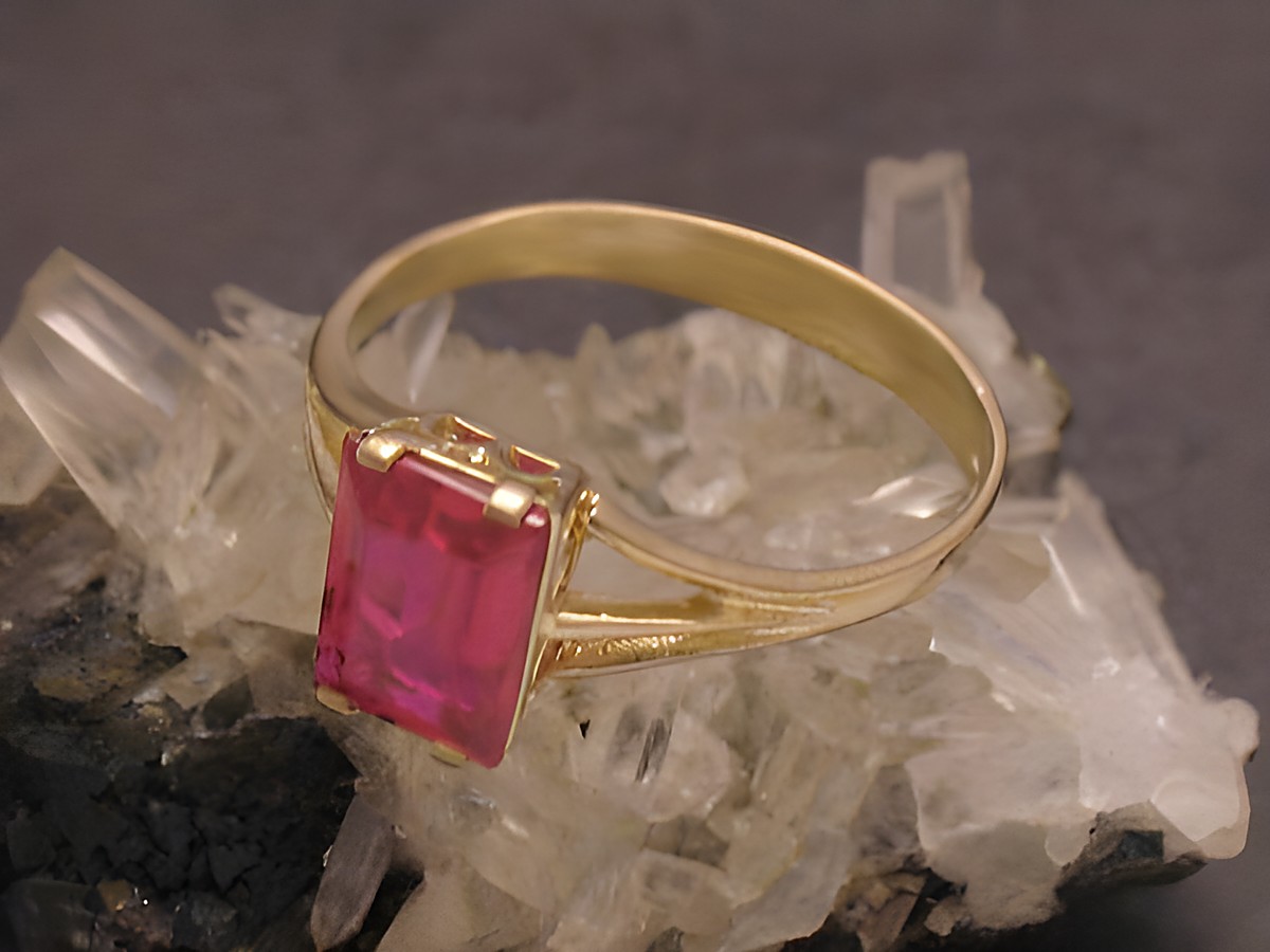 Goldring aus Gold 333 mit einem roten unechten Stein in Größe 54. Hersteller ist Juwelier Harnisch, geeignet bis Größe 54/17,5, edles Design auf Kristalluntergrund.