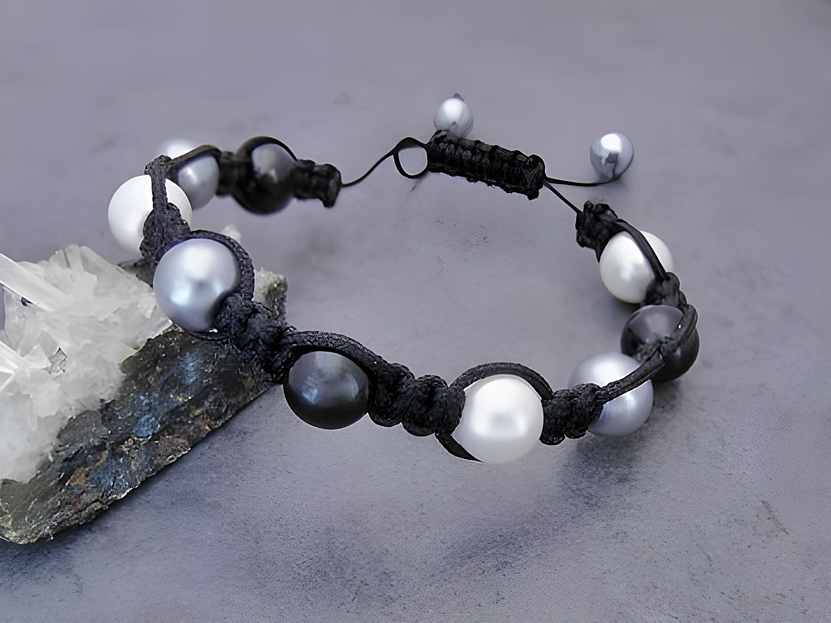Shamballah Armband in Weiß, Schwarz und Grau mit synthetischen Zuchtperlen, verziert mit einem stabilen Band, gefertigt von Juwelier Harnisch. Ideal für elegante Akzente.