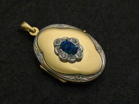 Ein bicolor Medaillon aus Gelbgold 585 mit einem blauen Opal Cabochon in Blumendesign, umgeben von Brillanten, gefertigt vom Juwelier Harnisch.