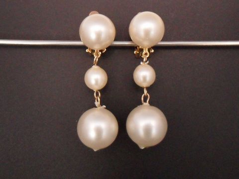 71878-0 Ohrclip perlweiß zeitlos mit goldfarbener Fassung aus Kunstharz, gefertigt vom Juwelier Harnisch, zeigt eine elegante Kombination von Perlen in verschiedenen Größen.