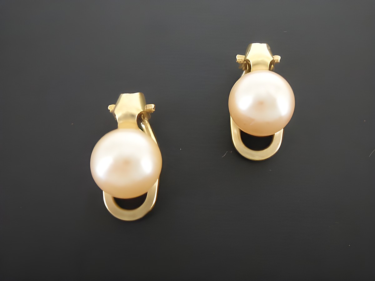 Ohrclip in hellrosa mit zeitlosem Design, verziert mit goldfarbener Synthese Zuchtperle, hergestellt von Juwelier Harnisch. Ideal für jeden Anlass.