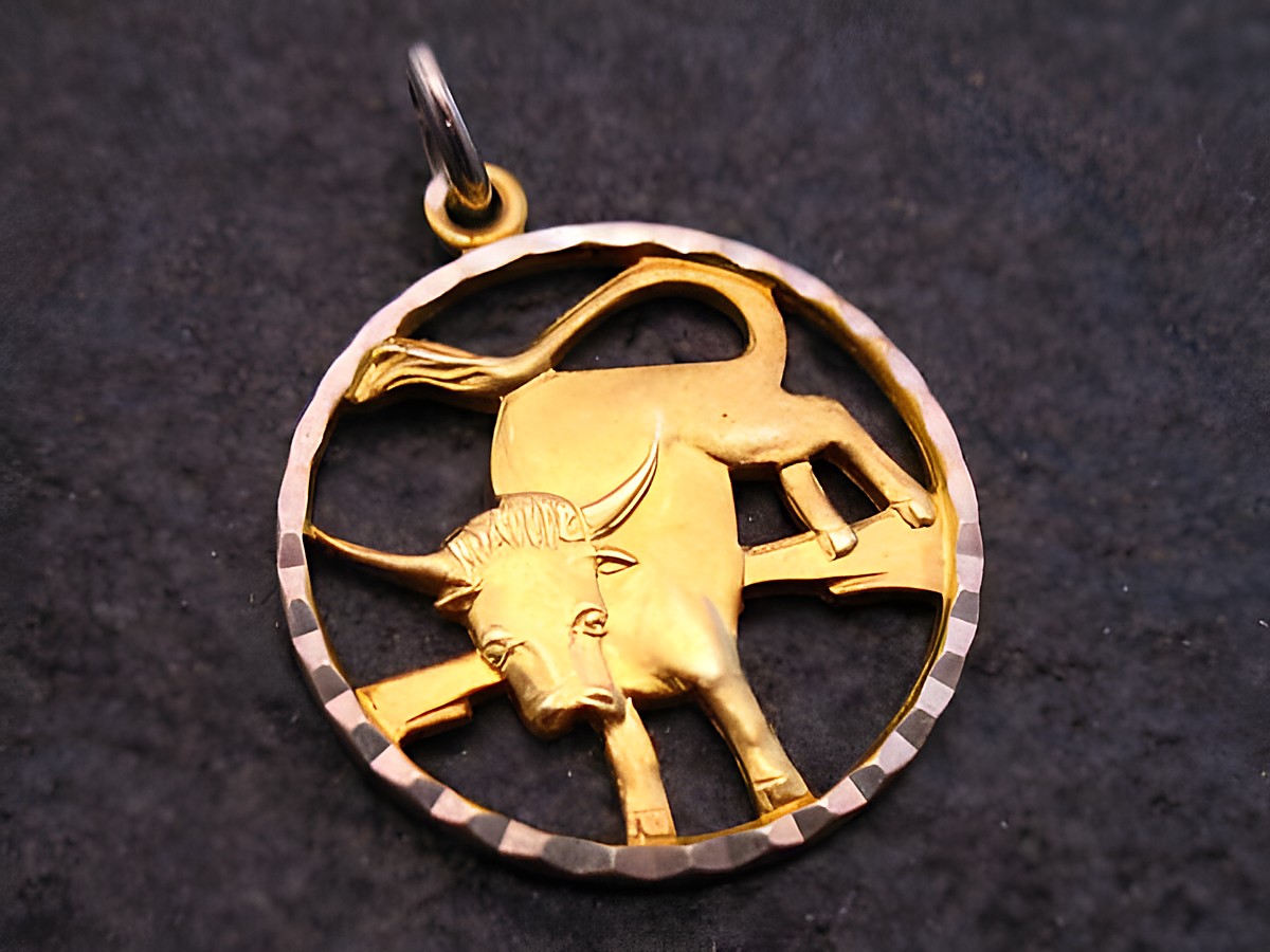 Anhänger aus Gold und Silber mit dem Sternzeichen Stier, hergestellt von Juwelier Harnisch, präsentiert ein kunstvolles Design mit einem stilisierten Stier im Kreis.