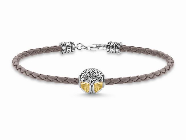 56969567-0 Ein geflochtenes graues Lederarmband mit einem Lebensbaum-Anhänger aus Sterling Silber, vergoldet und geschwärzt, der stilvoll in der Mitte des Armbands platziert ist.