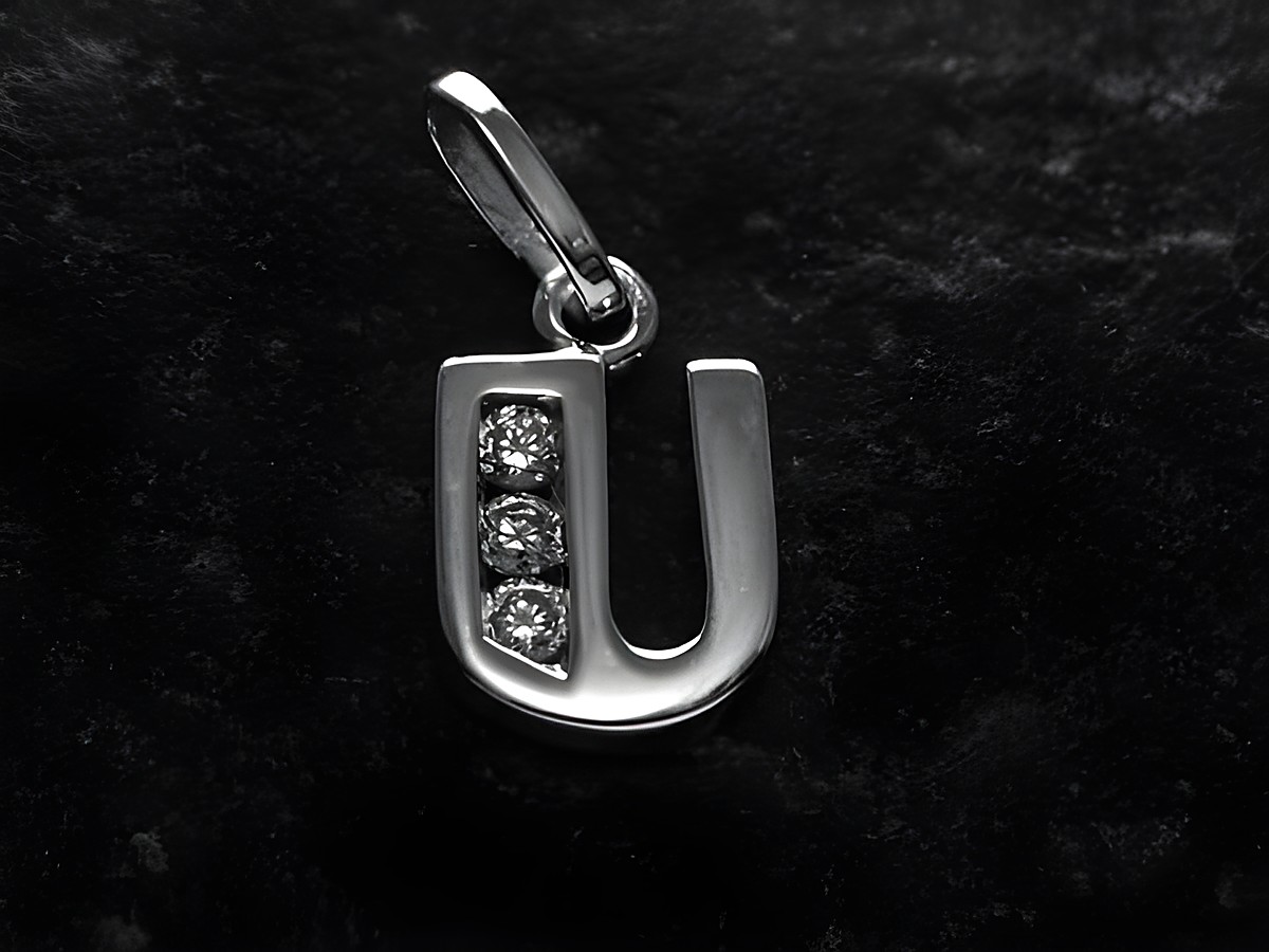 Anhänger in Form des Buchstabens U aus rhodiniertem Silber mit drei Zirkonia-Steinen, hergestellt von Juwelier Harnisch, glänzende Oberfläche und modernes Design.