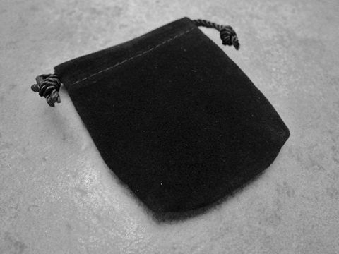 Schwarzes, viereckiges Geschenksäckchen aus Samt vom Juwelier Harnisch, ideal für Schmuck und kleine Geschenke, mit Zugkordeln zum sicheren Verschließen.
