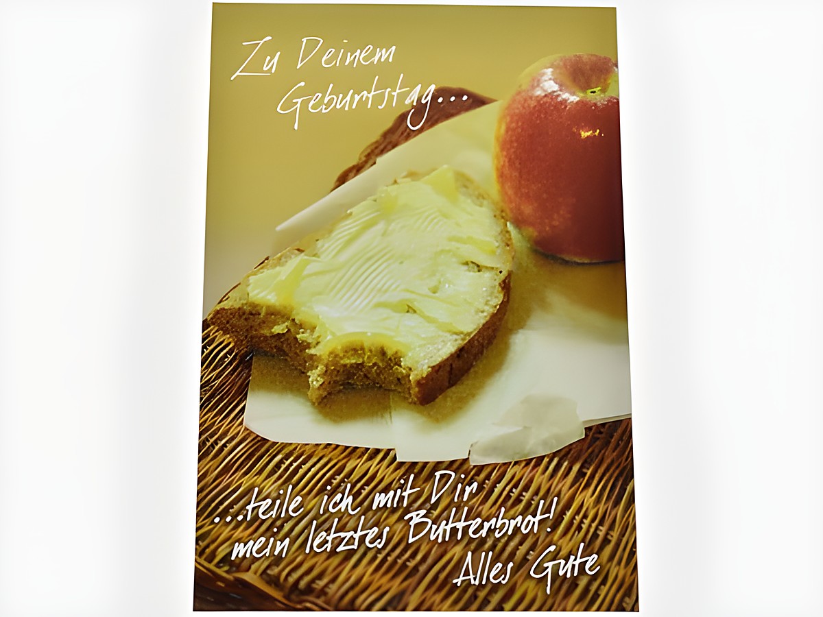 Eine Geburtstagskarte zeigt ein Butterbrot mit Butter und einen roten Apfel auf einem Tisch. Hersteller ist Juwelier Harnisch. Der Text auf der Karte wünscht alles Gute zum Geburtstag.
