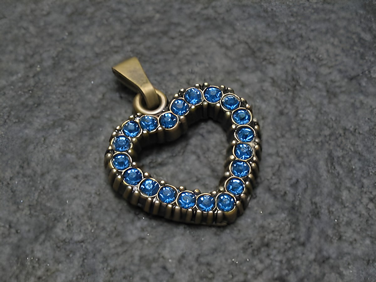 Blauer Strass Anhänger im Herzdesign, ideal für einen sexy City Look, hergestellt von Juwelier Harnisch, verziert mit funkelnden blauen Strasssteinen.
