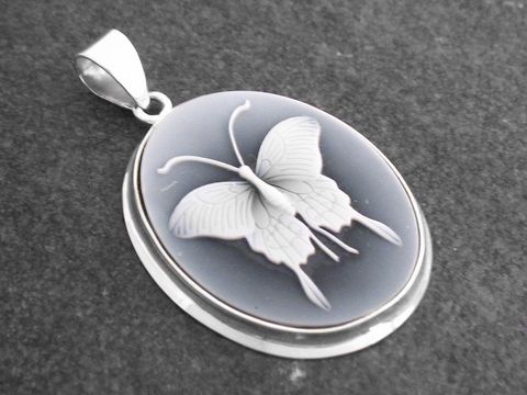 Der Anhänger zeigt einen filigranen Schmetterling aus Achat in einer ovalen Form, eingefasst in hochwertigem Sterling Silber, gefertigt von Juwelier Harnisch.