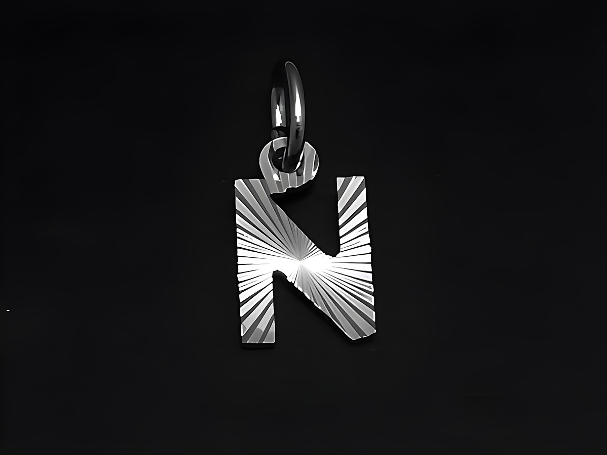 Silber Anhänger mit dem Buchstaben N, Druck- und Diamantschliff, hergestellt von Juwelier Harnisch. Der Anhänger hat eine glänzende Oberfläche und ein modernes Design.