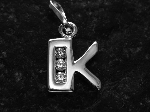 Anhänger aus Silber mit rhodiniertem Finish in Form des Buchstabens K, verziert mit drei Zirkonia-Steinen, hergestellt von Juwelier Harnisch.