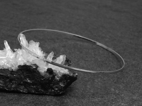 Silber Armreifen weiblich 1,5 mm rhodiniert 19,5 cm von Hersteller Juwelier Harnisch, elegant auf einer schwarzen Unterlage mit Kristallen abgebildet.