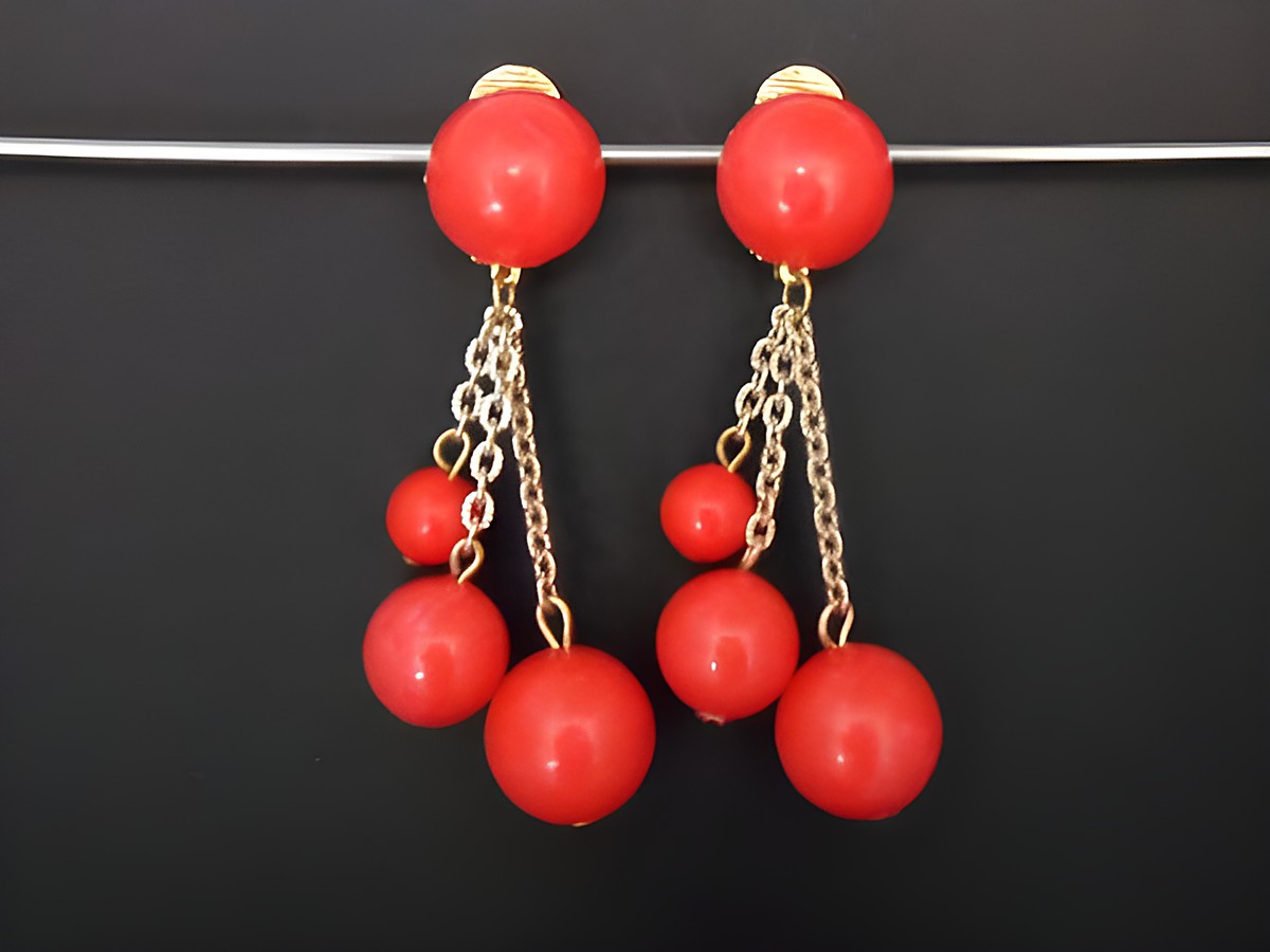 Ohrclips in rot mit zeitlosem Design aus Kunstharz und goldfarbenen Details, hergestellt von Juwelier Harnisch, elegant und auffällig.