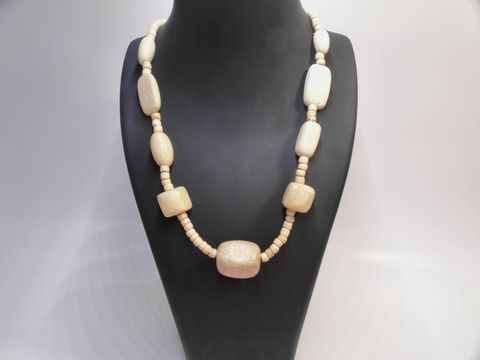 Holzkette aus naturbraunem Holz mit einer Länge von 60 cm und einer Breite von 25 mm, hergestellt von Juwelier Harnisch, auf einem Schmuckständer präsentiert.
