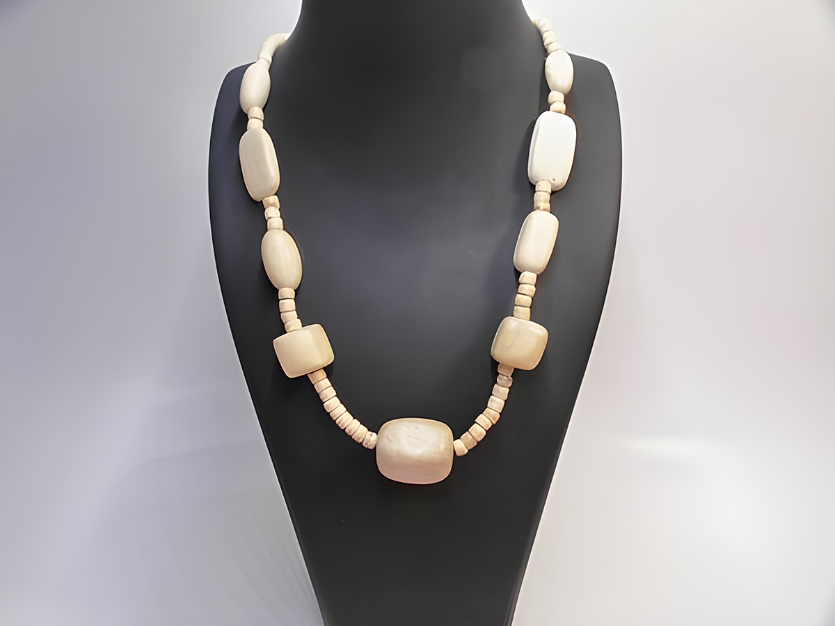 Holzkette aus naturbraunem Holz mit einer Länge von 60 cm und einer Breite von 25 mm, hergestellt von Juwelier Harnisch, auf einem Schmuckständer präsentiert.