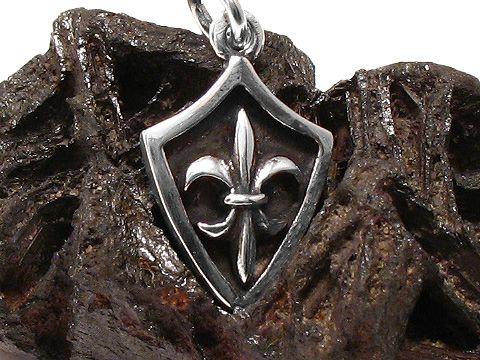 Bourbonische Lilie in 925 Sterling Silber als Anhänger, auf einer dunklen, strukturierten Oberfläche präsentiert, hergestellt von Juwelier Harnisch, weitere Anhänger verfügbar.
