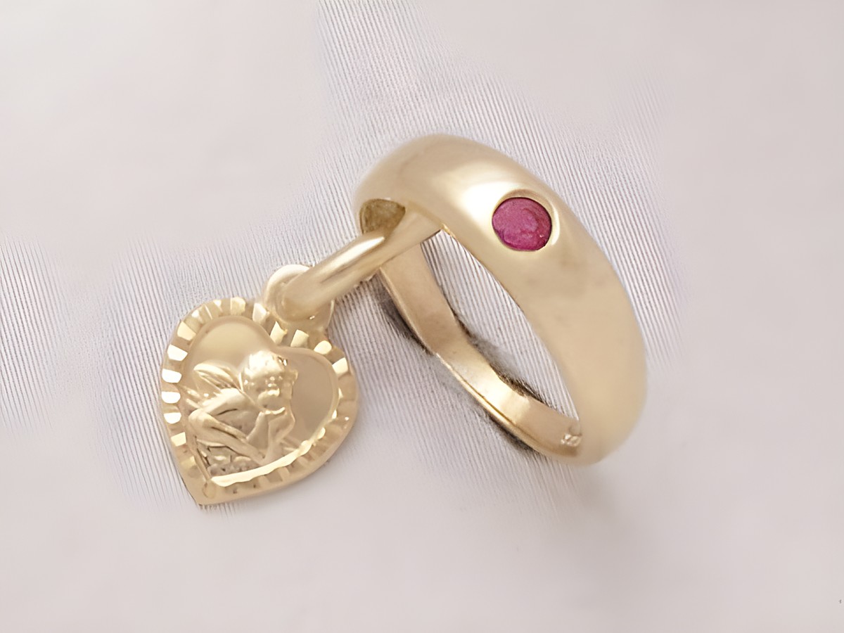 Taufring aus Gold 333 mit einem Schutzengel und Herz-Anhänger, verziert mit einem Rubin. Hergestellt von Juwelier Harnisch. Ideal als symbolisches Schmuckstück.