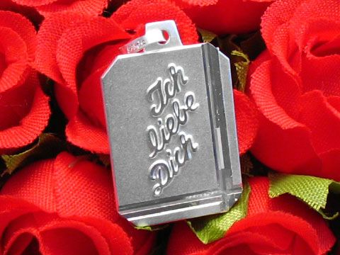 Silber Gravurplatte Rechteck DIAMANTSCHLIFF von Juwelier Harnisch mit dem gravierten Text Ich liebe Dich, auf rotem Rosenteppich platziert.