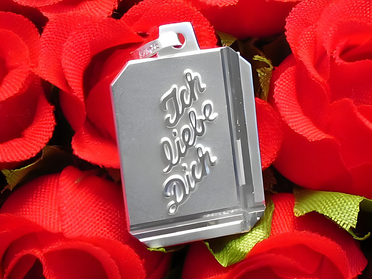 Silber Gravurplatte Rechteck DIAMANTSCHLIFF von Juwelier Harnisch mit dem gravierten Text Ich liebe Dich, auf rotem Rosenteppich platziert.