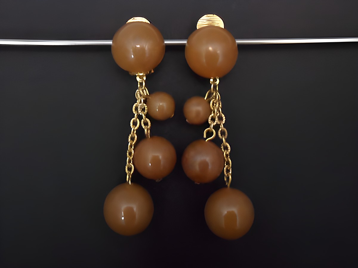 Ohrclip in braun zeitlos mit goldfarbenen Akzenten aus Kunstharz, Hersteller Juwelier Harnisch, elegantes Design mit mehreren unterschiedlich großen Perlen, perfekt für besondere Anlässe.