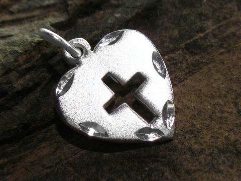 Herz mit ausgestanztem Kreuz aus Sterling Silber, gefertigt von Juwelier Harnisch, mit filigranem Muster und glänzender Oberfläche, ideal als Schmuckstück.