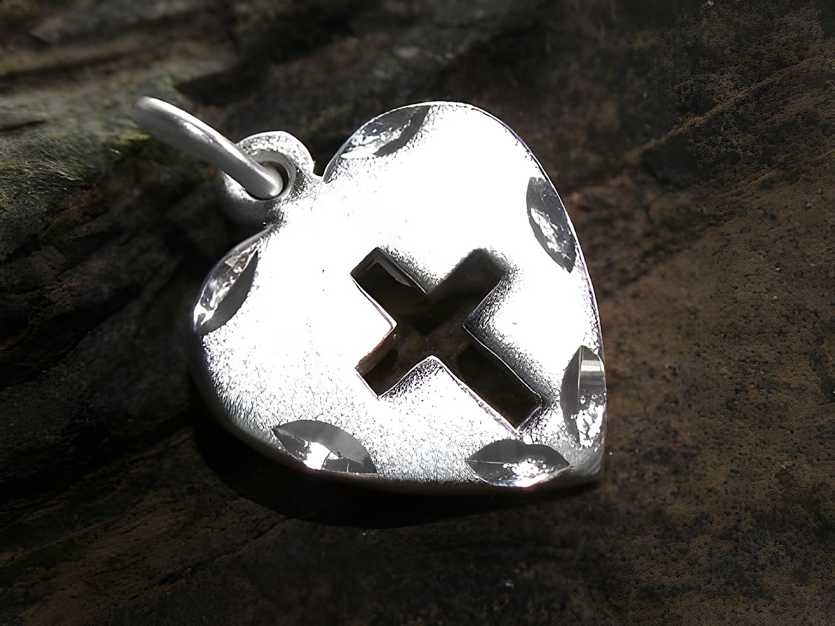 Herz mit ausgestanztem Kreuz aus Sterling Silber, gefertigt von Juwelier Harnisch, mit filigranem Muster und glänzender Oberfläche, ideal als Schmuckstück.